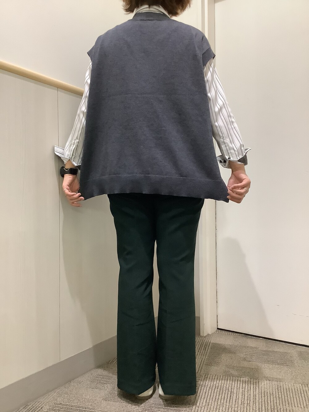 グレー系のビジネスシャツ、グレー系のベストを着用したレディースの秋コーディネートの4枚目の写真