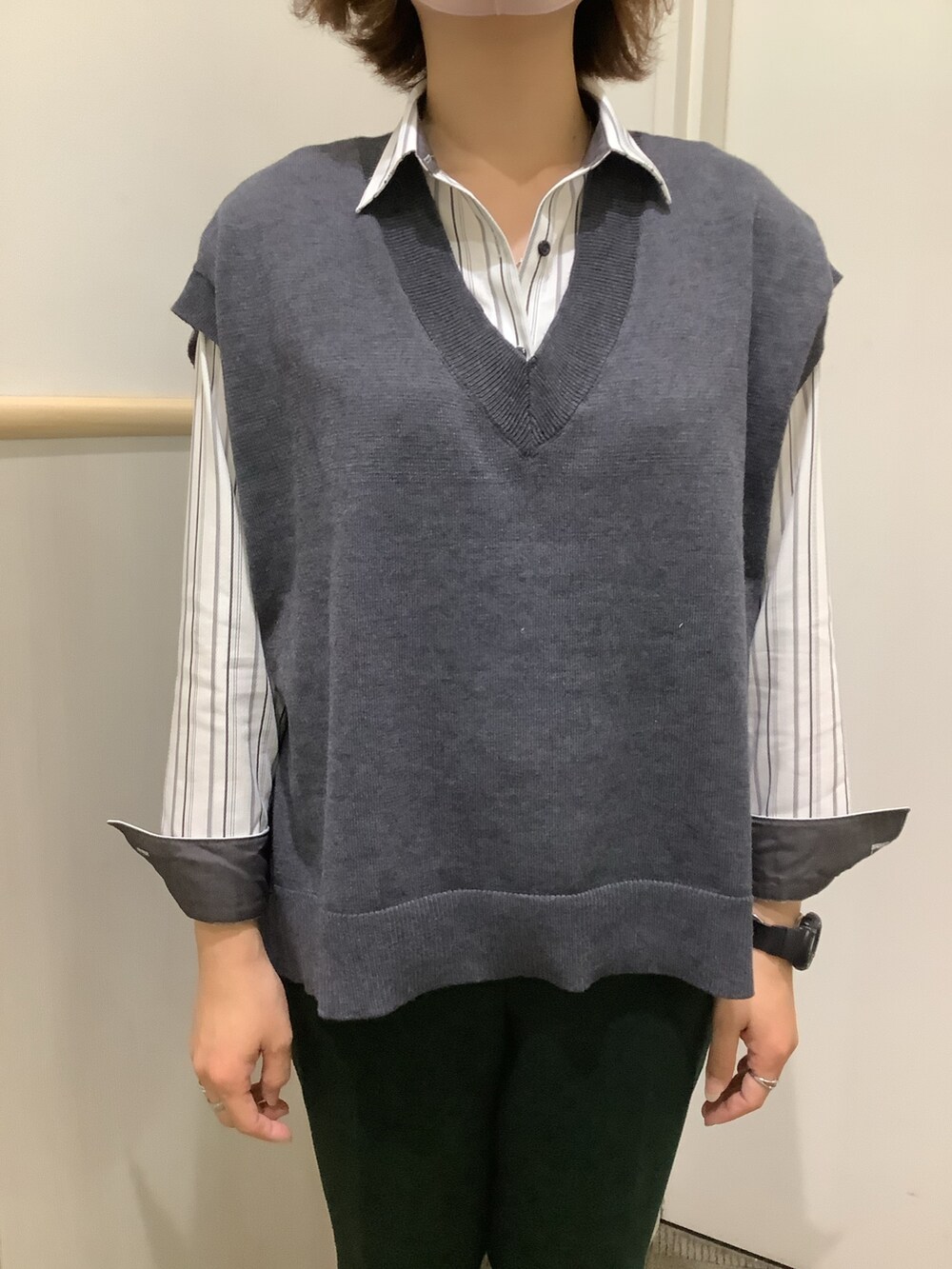 グレー系のビジネスシャツ、グレー系のベストを着用したレディースの秋コーディネートの2枚目の写真