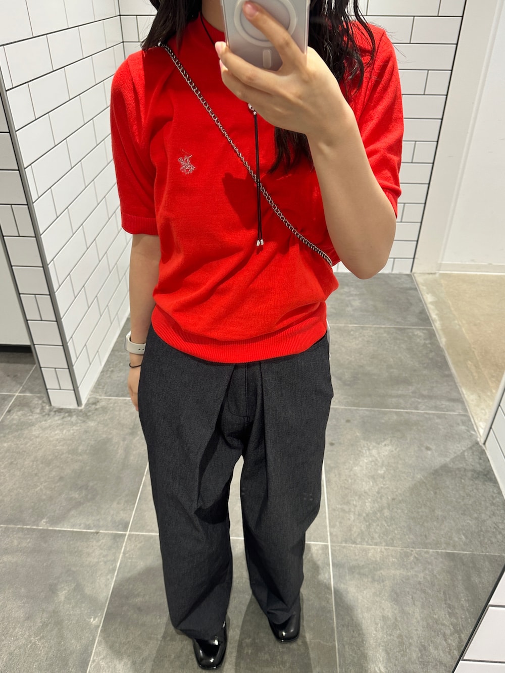 レッド系のトップス、ブラック系のその他パンツ、シルバー系のショルダーバッグを着用したレディースの夏コーディネートの2枚目の写真