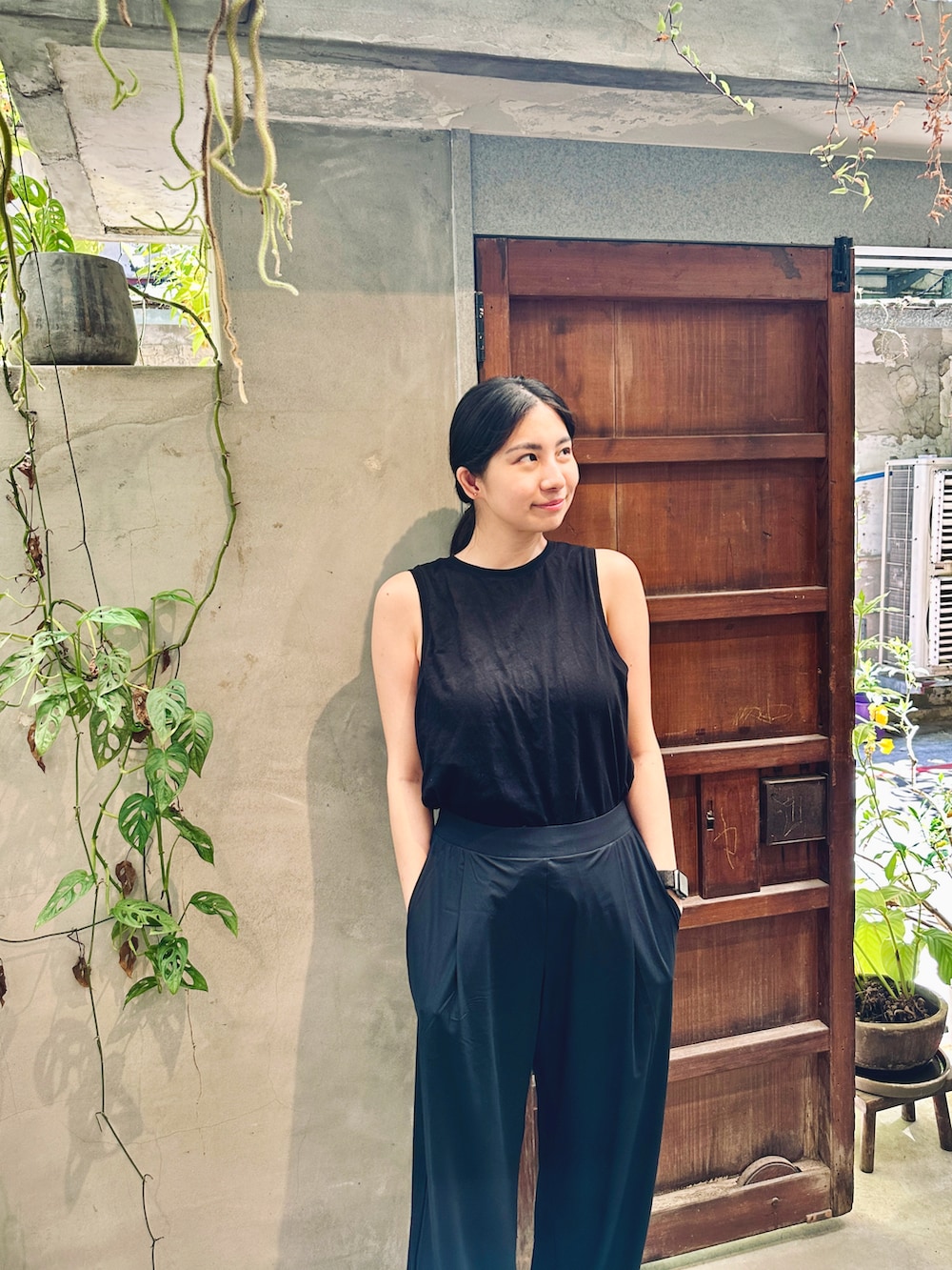 ブラック系のキャミソール、ブラック系のチノパンツを着用したレディースの夏コーディネートの2枚目の写真