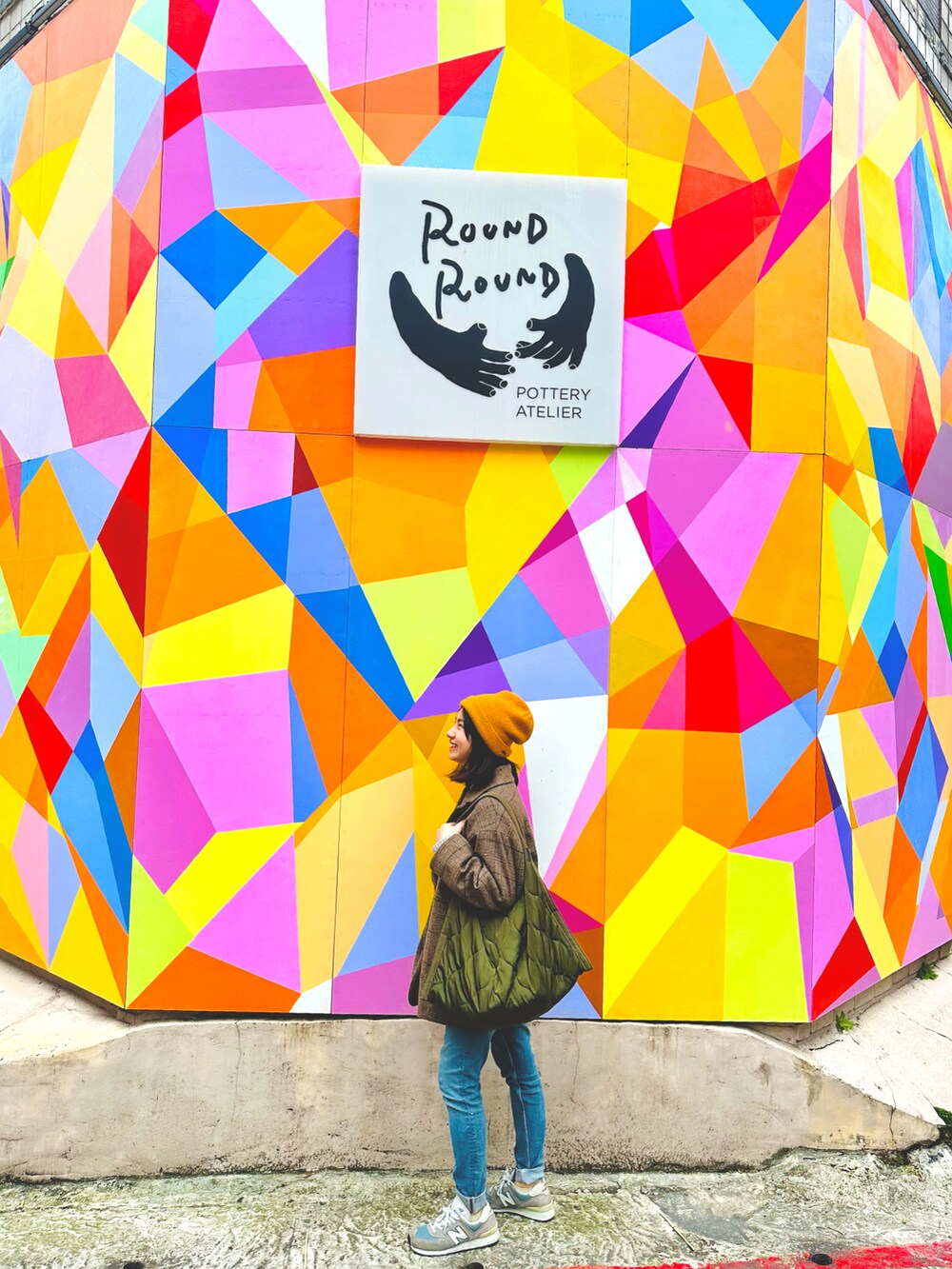 ブルー系のデニムパンツ、グレー系のスニーカー、ブラウン系のテーラードジャケットを着用したレディースの冬コーディネートの2枚目の写真