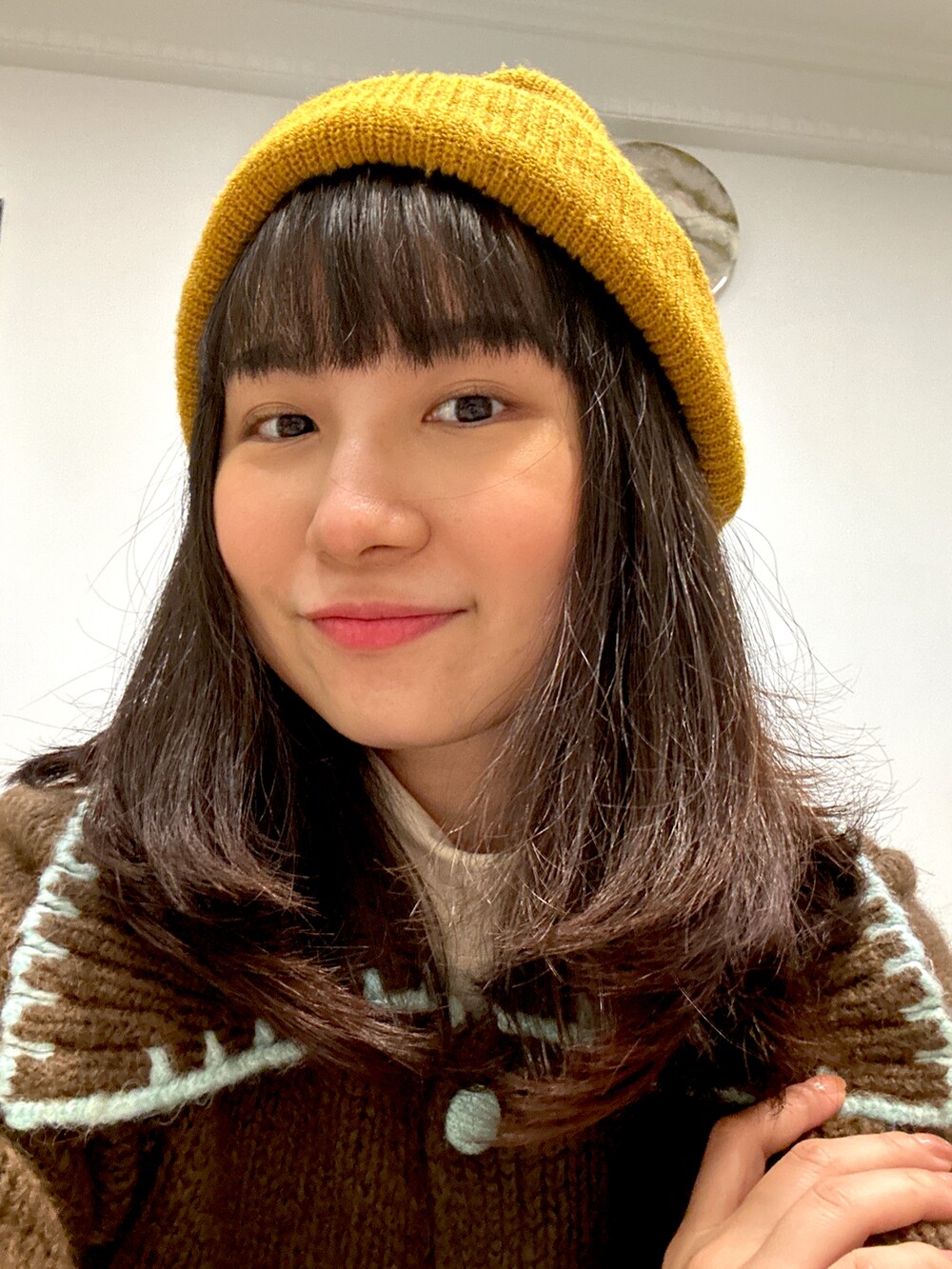 ブラウン系のニット/セーター、ホワイト系のショルダーバッグ、ブルー系のデニムパンツを着用したレディースの秋コーディネートの2枚目の写真