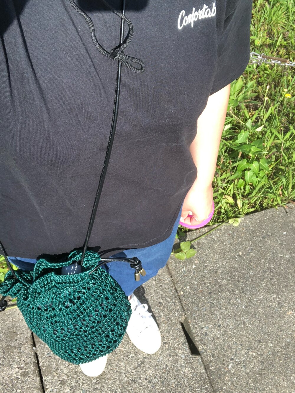 グリーン系のショルダーバッグ、ブラック系のTシャツ/カットソー、ブルー系のデニムパンツを着用したレディースの夏コーディネートの2枚目の写真