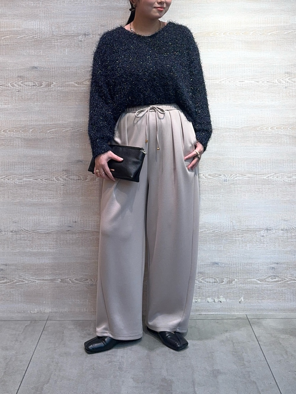 ベージュ系のその他パンツ、ブラック系のトートバッグ、ブルー系のニット/セーターを着用したレディースの冬コーディネートの3枚目の写真