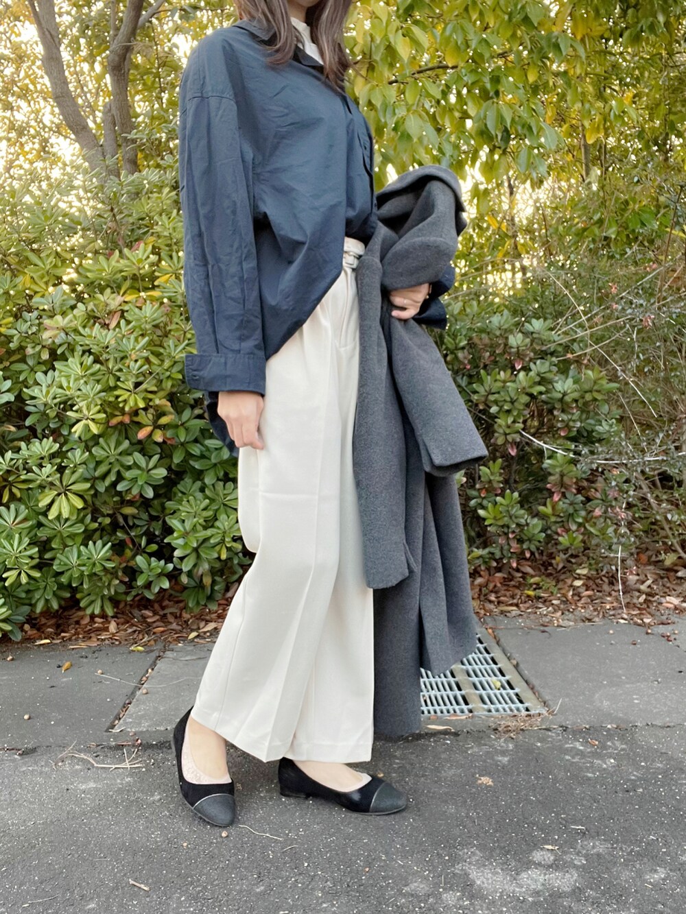 ベージュ系のシャツ/ブラウス、ホワイト系のスラックス、グレー系のチェスターコートを着用したレディースの冬コーディネートの2枚目の写真