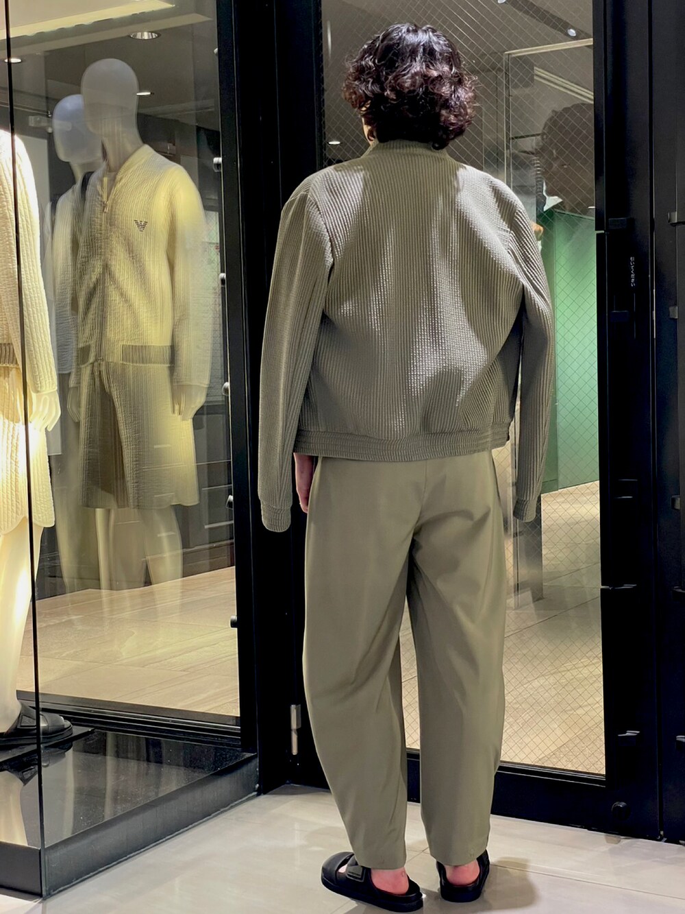 ブラック系のサンダル、グリーン系のスラックス、ブラック系のボディバッグ/ウエストポーチを着用したメンズの夏コーディネートの4枚目の写真