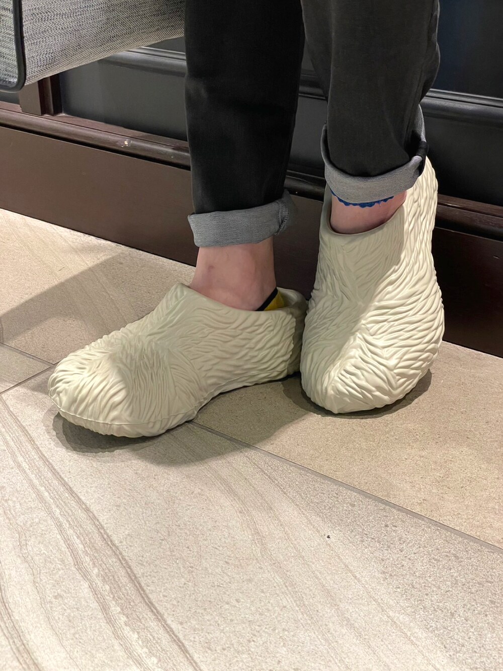 グレー系のトートバッグ、グレー系のスリッポン、ブラック系のTシャツ/カットソーを着用したメンズの春コーディネートの5枚目の写真