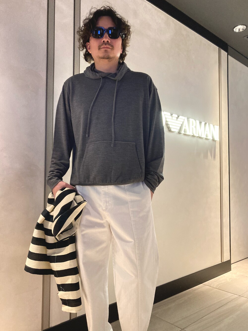 ホワイト系のチノパンツ、その他のブルゾン、ホワイト系のスニーカーを着用したメンズの春コーディネートの3枚目の写真