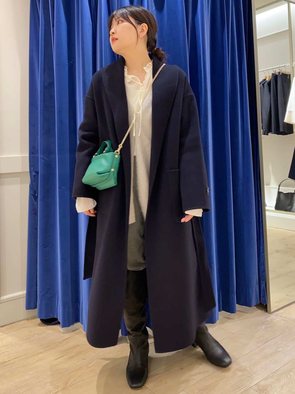 ベージュ系のカーディガン/ボレロ、ホワイト系のシャツ/ブラウス、ブラック系のブーツを着用したレディースの冬コーディネートの7枚目の写真