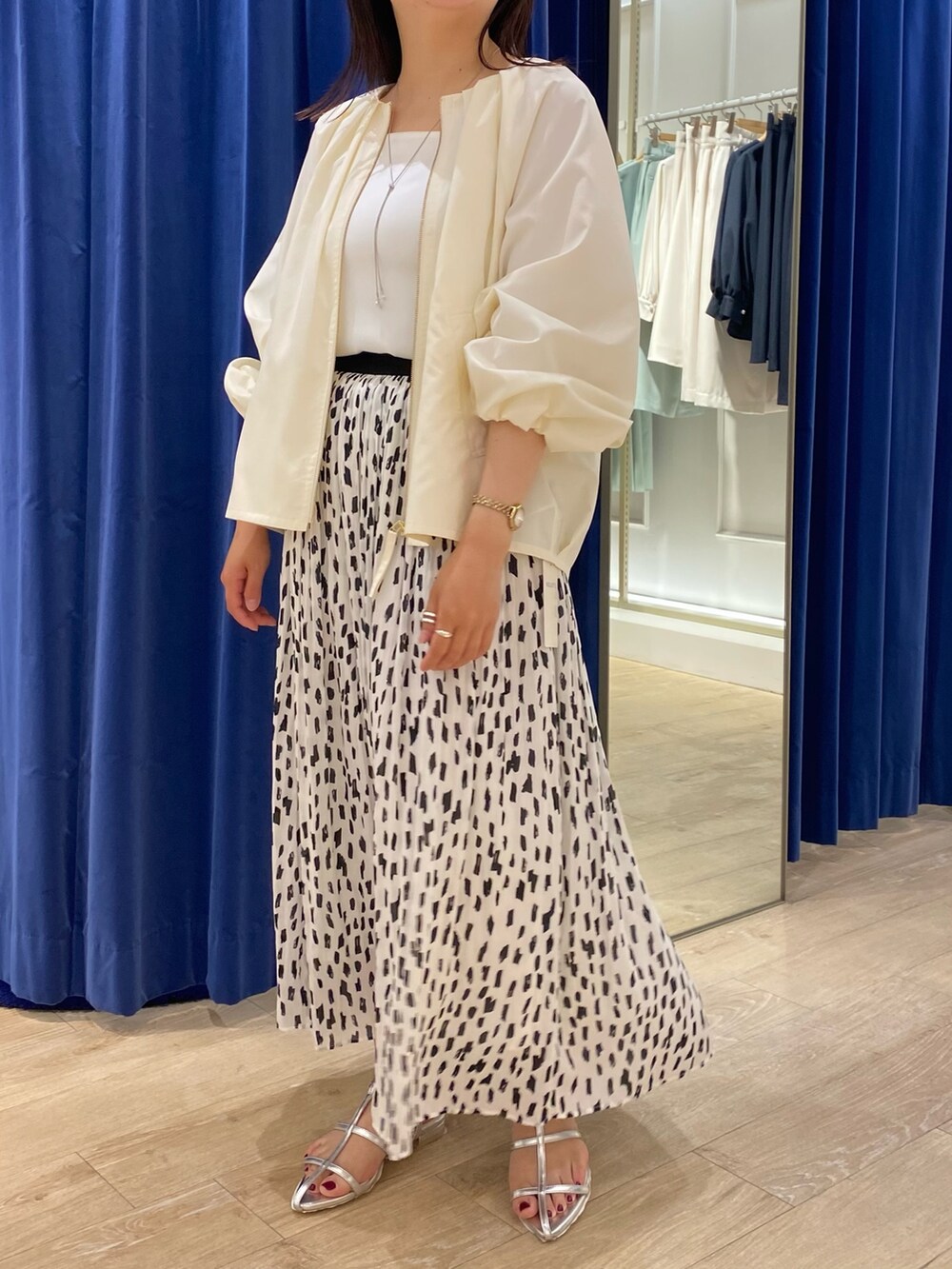 ホワイト系のブルゾン、ホワイト系のタンクトップ、ホワイト系のスカートを着用したレディースの春コーディネートの4枚目の写真