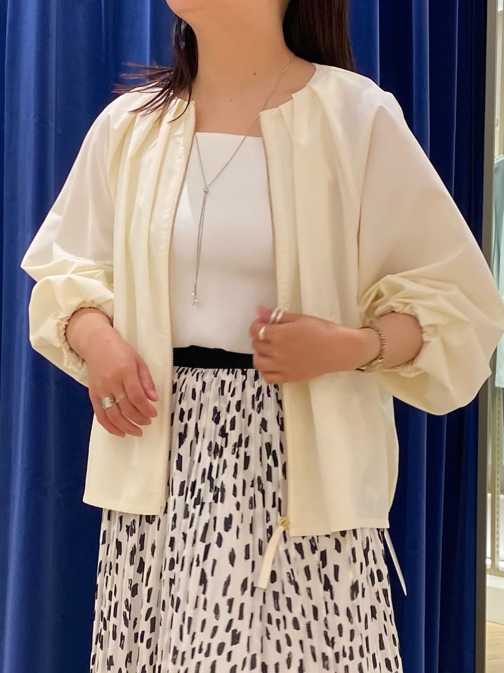 ホワイト系のブルゾン、ホワイト系のタンクトップ、ホワイト系のスカートを着用したレディースの春コーディネートの2枚目の写真