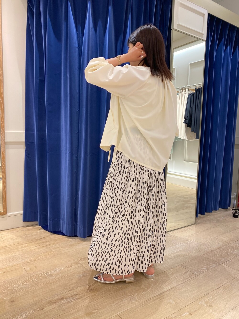 ホワイト系のブルゾン、ホワイト系のタンクトップ、ホワイト系のスカートを着用したレディースの春コーディネートの3枚目の写真