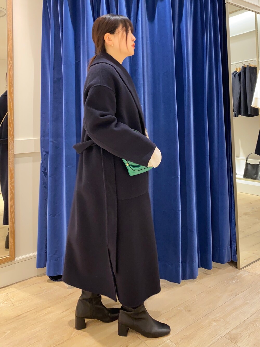 ベージュ系のカーディガン/ボレロ、ホワイト系のシャツ/ブラウス、ブラック系のブーツを着用したレディースの冬コーディネートの5枚目の写真