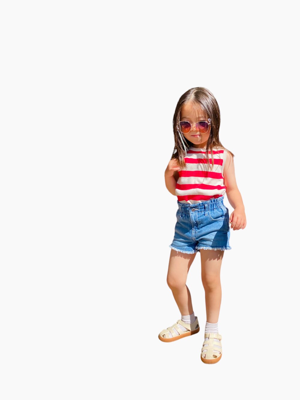 ブルー系のデニムパンツ、レッド系のタンクトップ、ホワイト系のサンダルを着用したキッズの春コーディネートの2枚目の写真