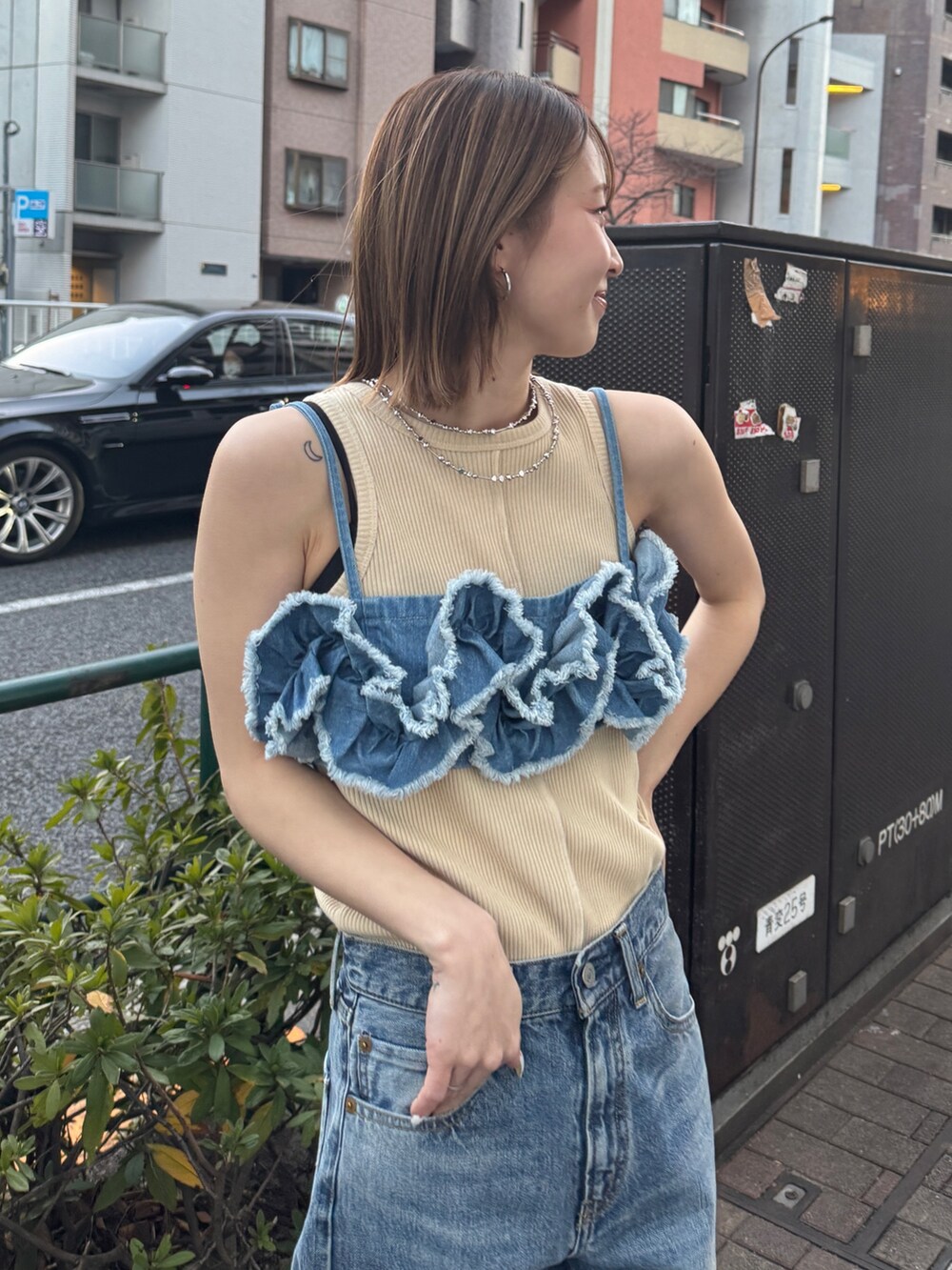 ブルー系のキャミソール、ホワイト系のタンクトップ、ブルー系のデニムパンツを着用したレディースの春コーディネートの4枚目の写真