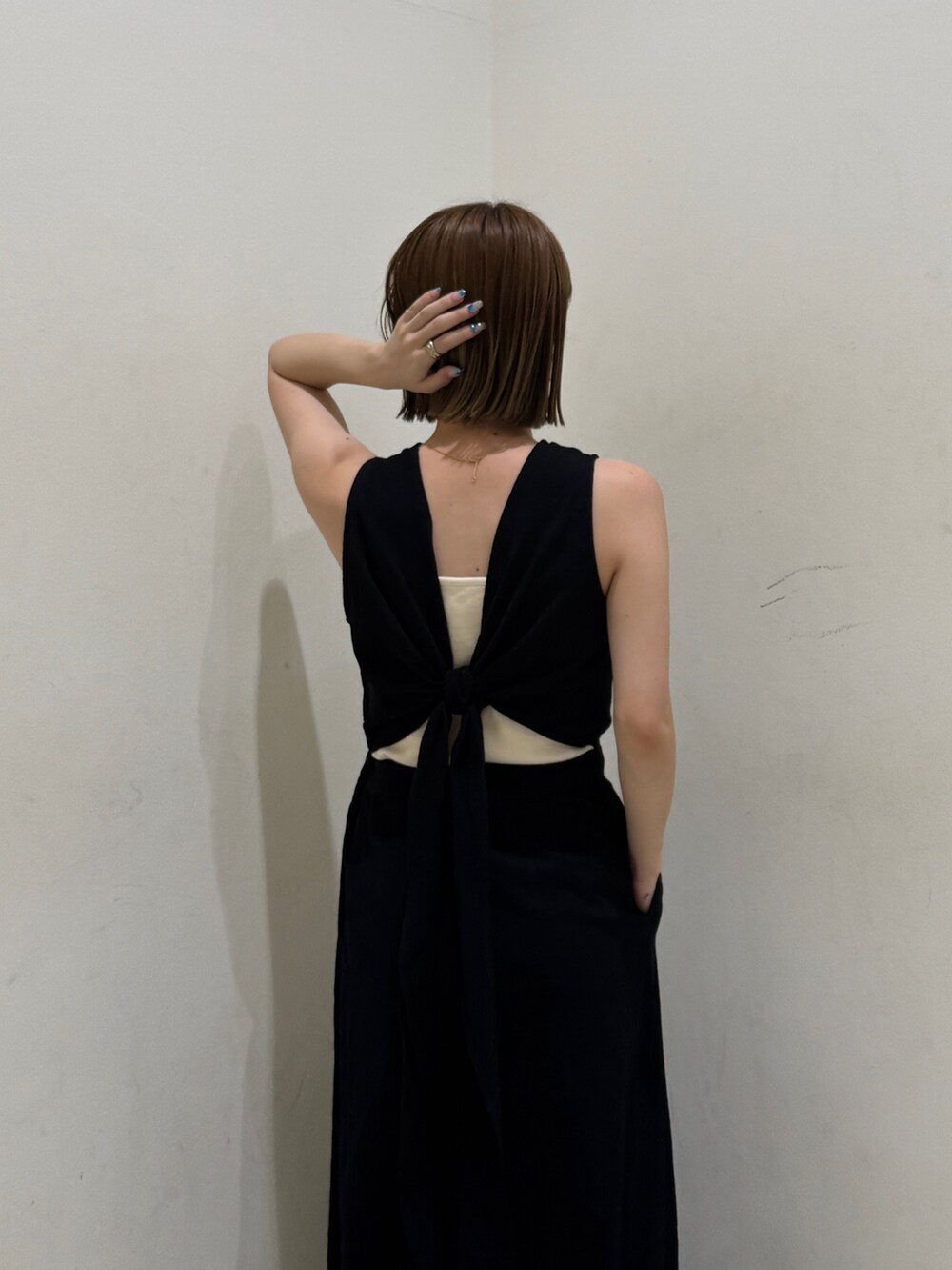 ホワイト系のキャミソール、ブラック系のワンピースを着用したレディースの夏コーディネートの6枚目の写真