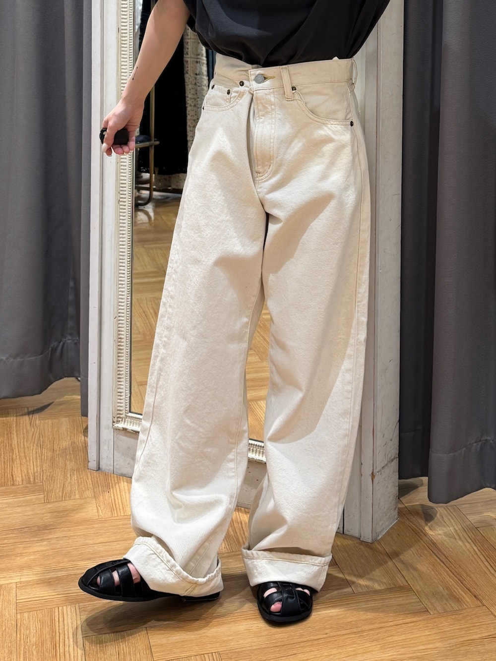 グレー系のTシャツ/カットソー、ホワイト系のデニムパンツ、ブラック系のサンダルを着用したレディースの春コーディネートの7枚目の写真