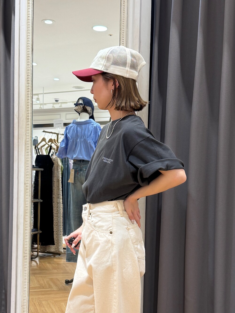 グレー系のTシャツ/カットソー、ホワイト系のデニムパンツ、ブラック系のサンダルを着用したレディースの春コーディネートの5枚目の写真