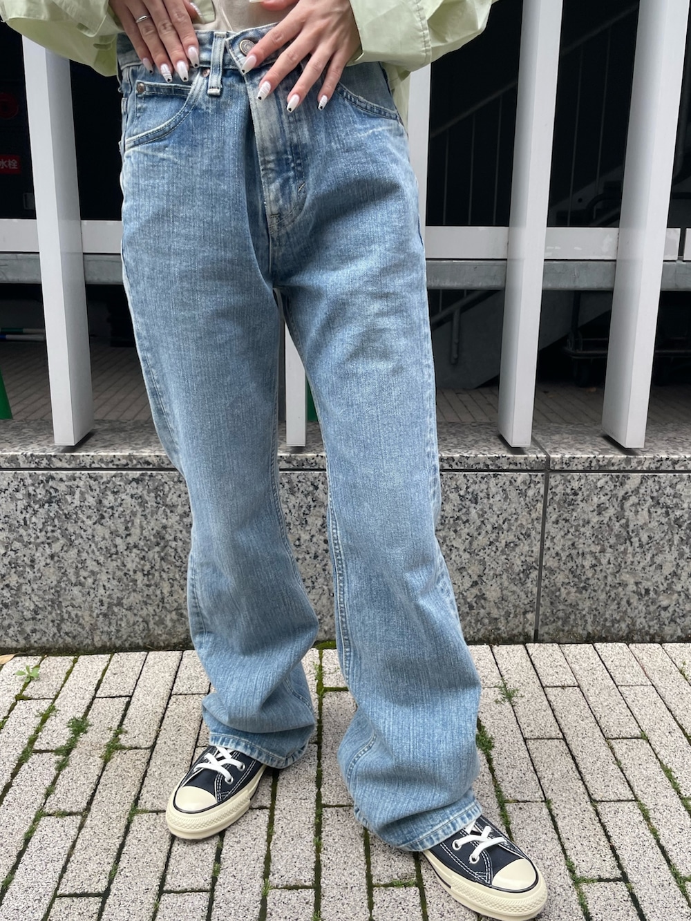 グリーン系のシャツ/ブラウス、ホワイト系のキャミソール、ブルー系のデニムパンツを着用したレディースの春コーディネートの5枚目の写真