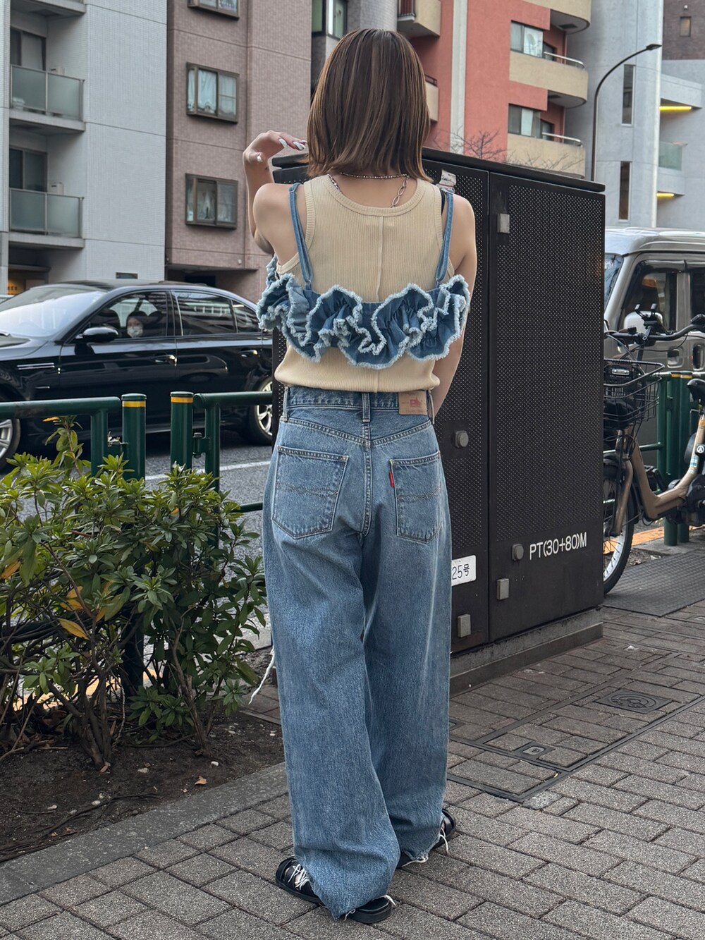 ブルー系のキャミソール、ホワイト系のタンクトップ、ブルー系のデニムパンツを着用したレディースの春コーディネートの3枚目の写真