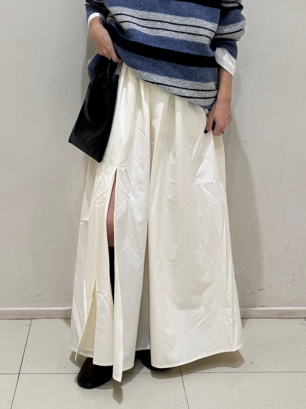 ブルー系のニット/セーター、ホワイト系のTシャツ/カットソー、ホワイト系のスカートを着用したレディースの秋コーディネートの5枚目の写真