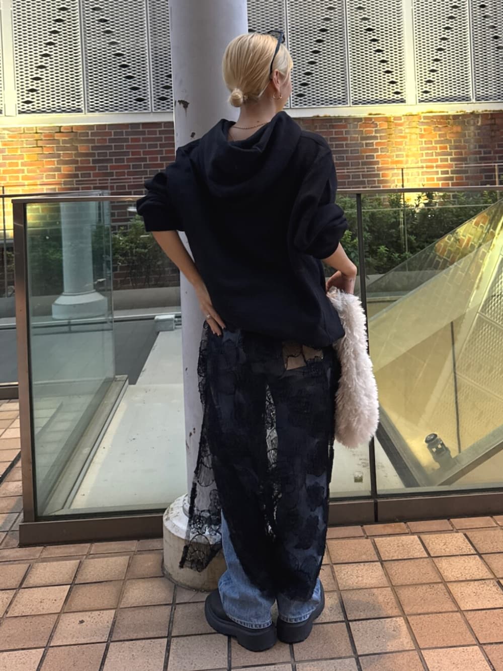 ブラック系のパーカー、ブラック系のスカート、ブルー系のデニムパンツを着用したレディースの秋コーディネートの3枚目の写真