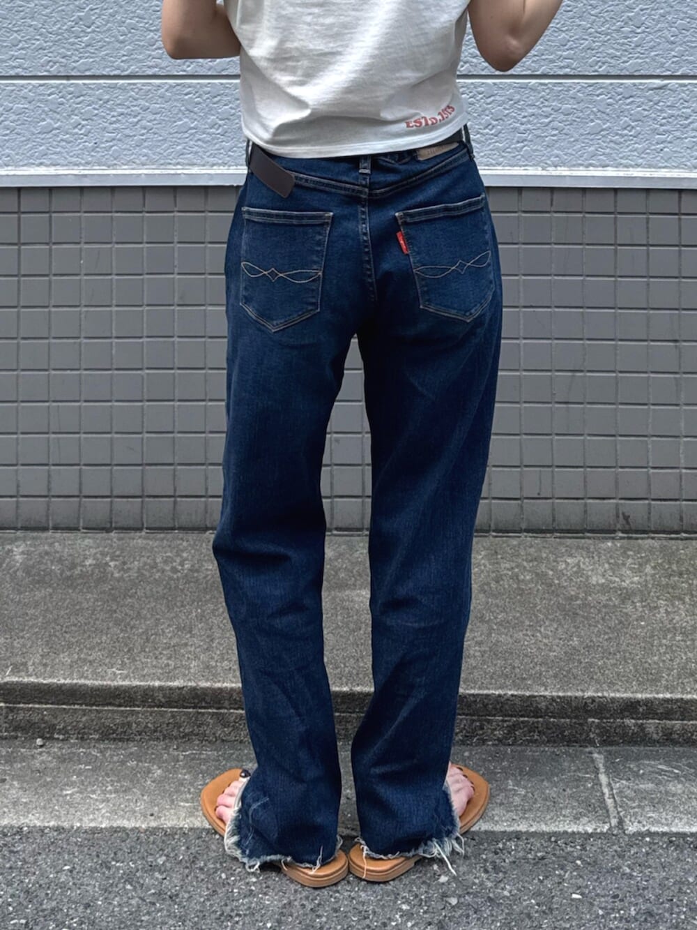 シルバー系のサンダル、ブルー系のデニムパンツ、ホワイト系のTシャツ/カットソーを着用したレディースの夏コーディネートの6枚目の写真