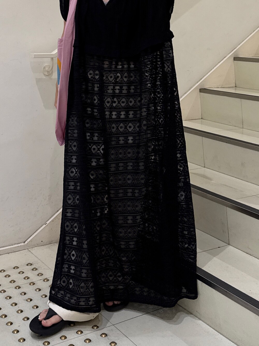 ブラック系のワンピース、ホワイト系のデニムパンツ、ピンク系のトートバッグを着用したレディースの夏コーディネートの4枚目の写真