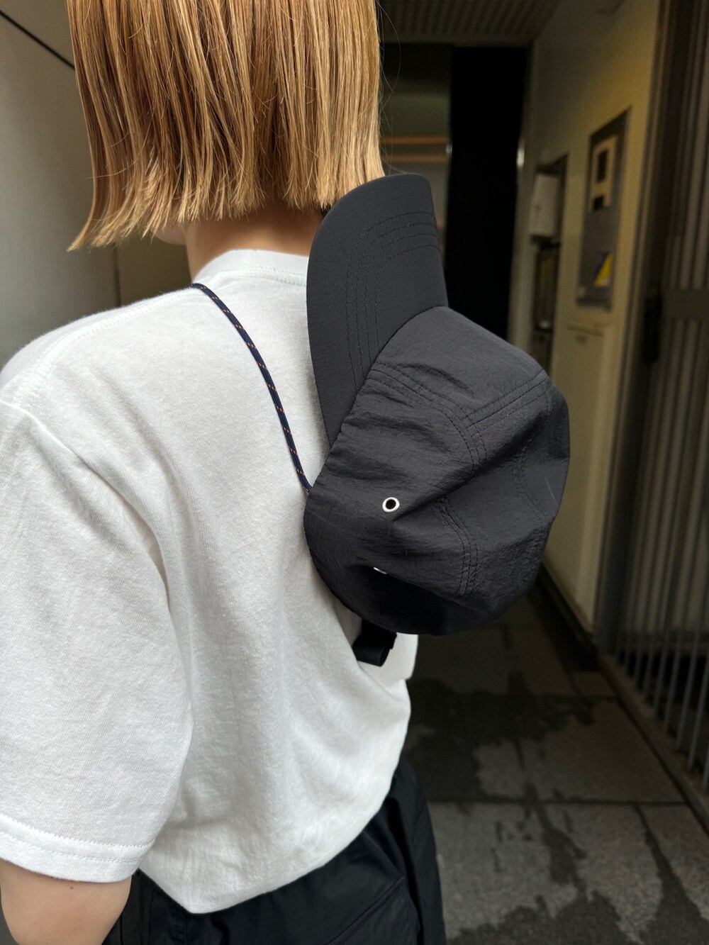 ホワイト系のTシャツ/カットソー、ブラック系のカーゴパンツ、ブラック系のサンダルを着用したレディースの夏コーディネートの6枚目の写真