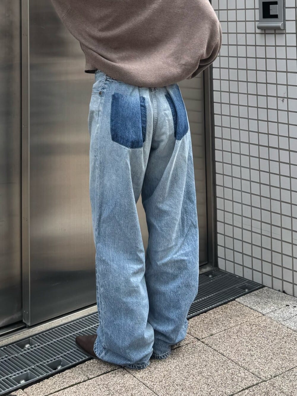 ブラウン系のブーツ、ブルー系のデニムパンツ、ベージュ系のニット/セーターを着用したレディースの秋コーディネートの5枚目の写真