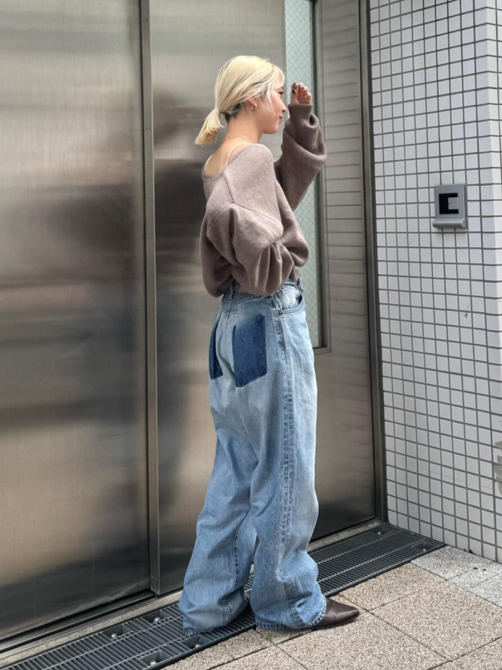 ブラウン系のブーツ、ブルー系のデニムパンツ、ベージュ系のニット/セーターを着用したレディースの秋コーディネートの2枚目の写真