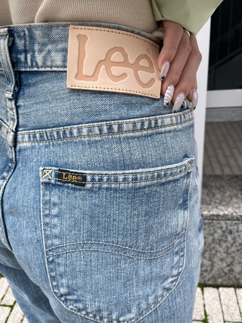 グリーン系のシャツ/ブラウス、ホワイト系のキャミソール、ブルー系のデニムパンツを着用したレディースの春コーディネートの9枚目の写真