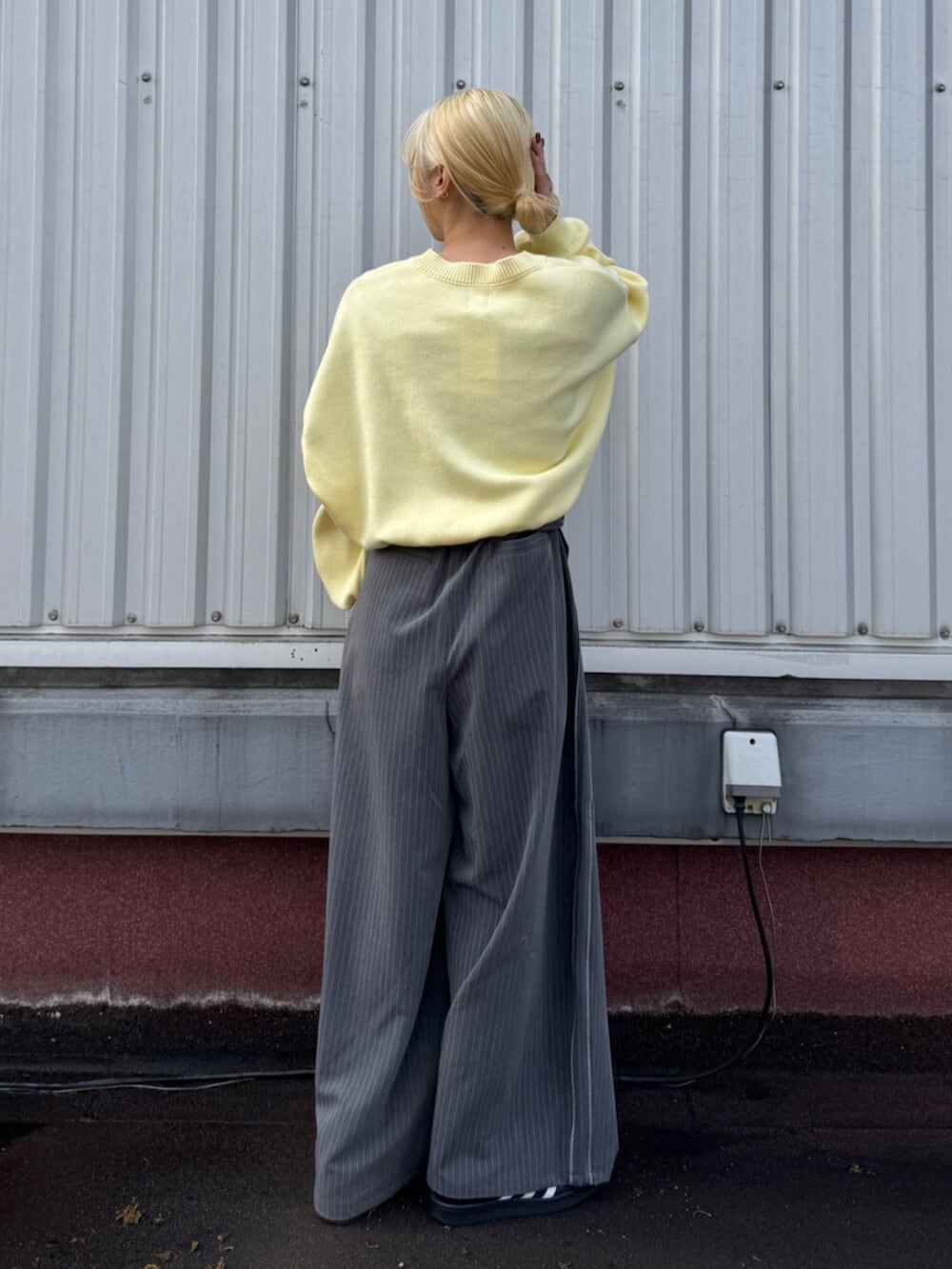 グレー系のその他パンツ、イエロー系のニット/セーターを着用したレディースの冬コーディネートの3枚目の写真