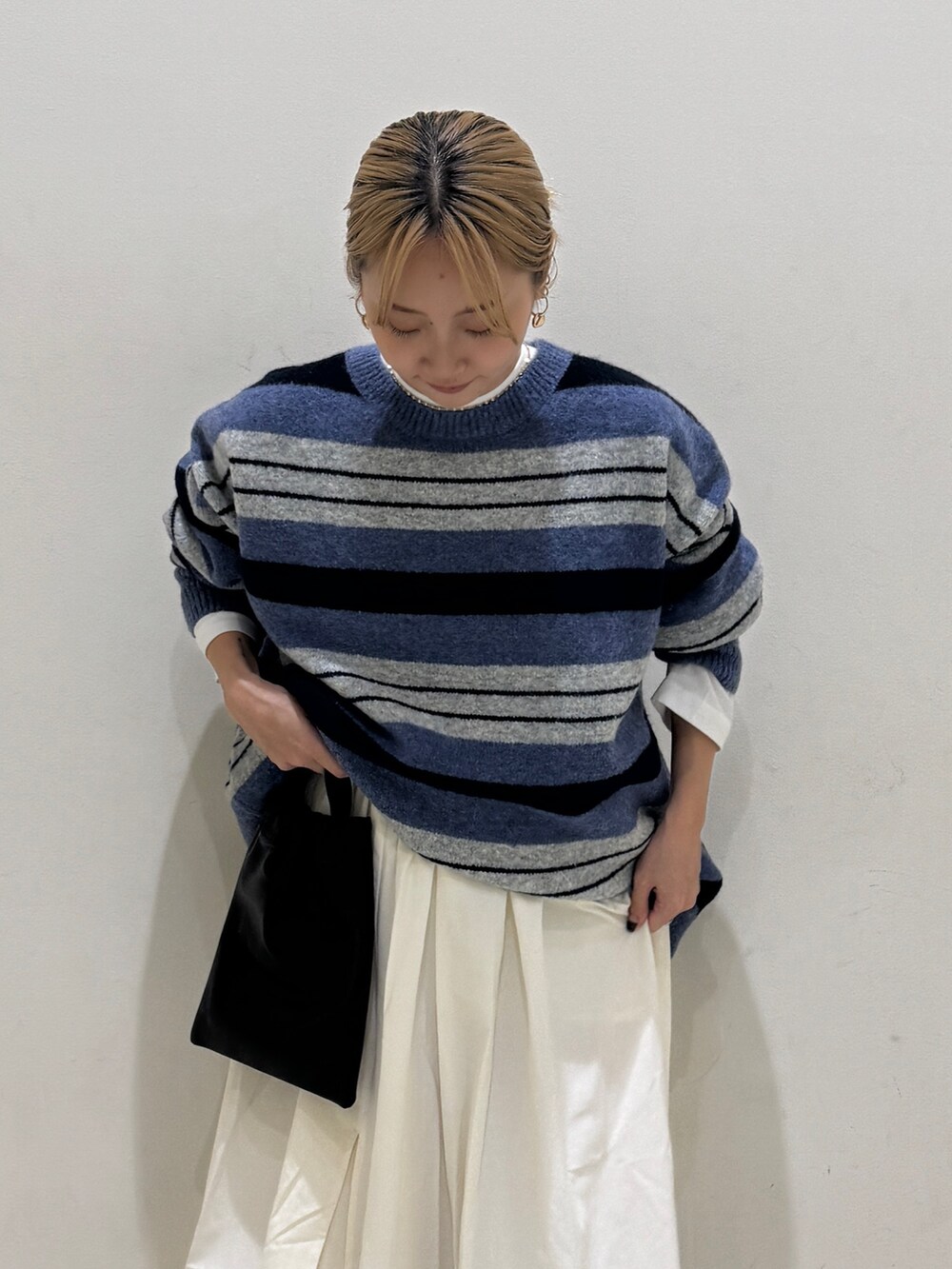 ブルー系のニット/セーター、ホワイト系のTシャツ/カットソー、ホワイト系のスカートを着用したレディースの秋コーディネートの4枚目の写真