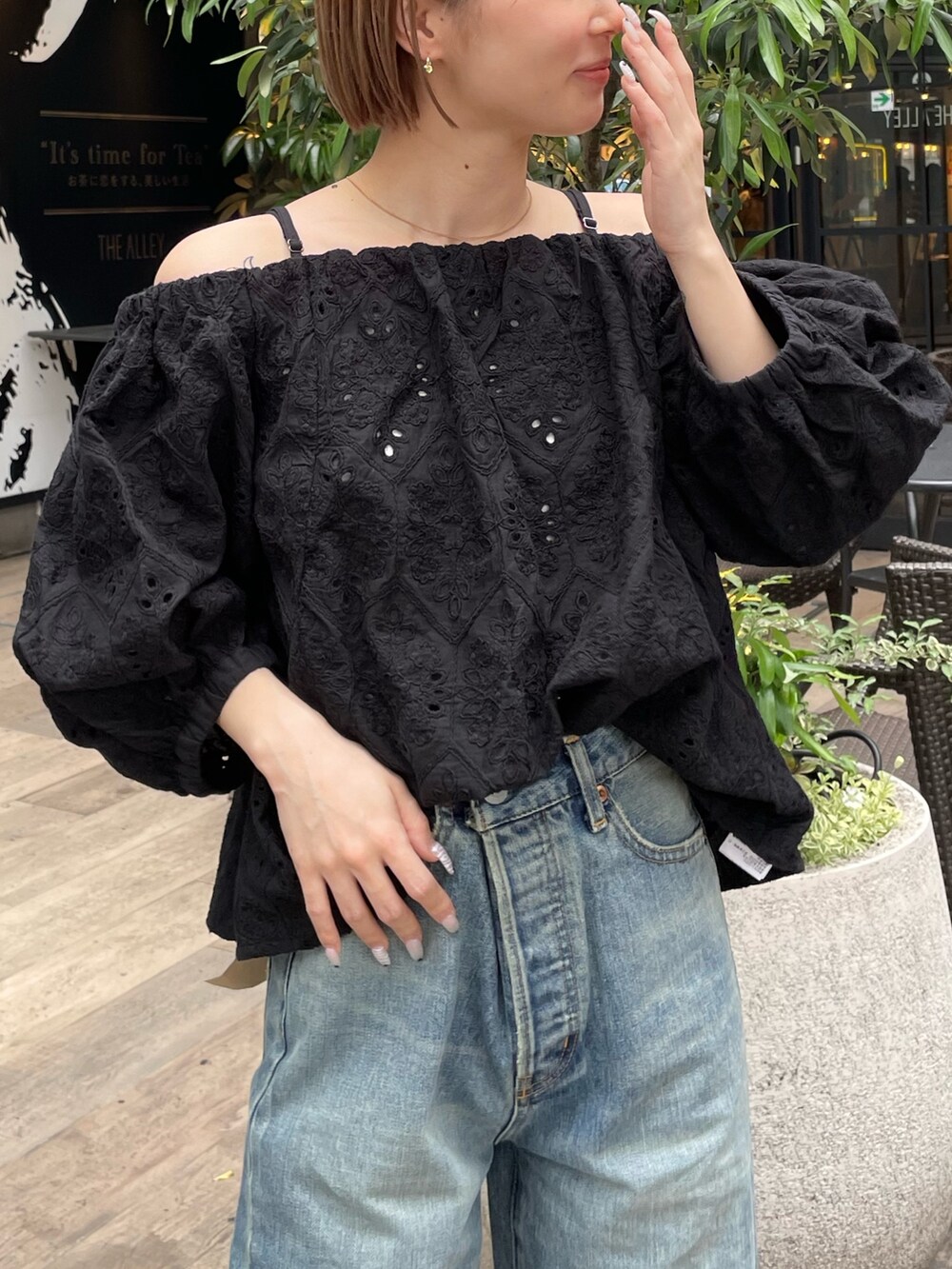 ブラック系のシャツ/ブラウス、ブルー系のデニムパンツ、ゴールド系のパンプスを着用したレディースの春コーディネートの4枚目の写真