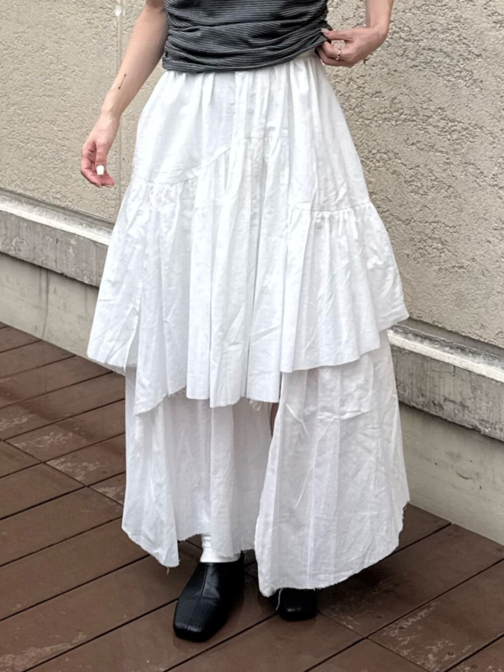 ブラック系のサンダル、グレー系のTシャツ/カットソー、ホワイト系のスカートを着用したレディースの夏コーディネートの5枚目の写真