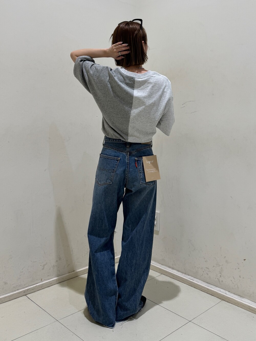 ブルー系のデニムパンツ、グレー系のTシャツ/カットソー、シルバー系のネックレスを着用したレディースの春コーディネートの3枚目の写真