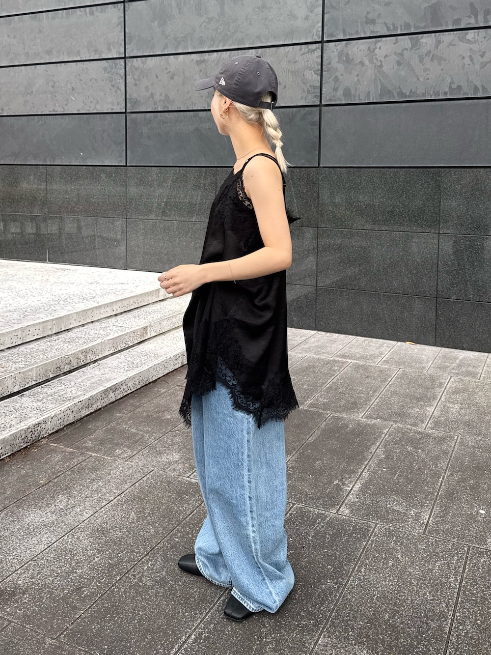ブラック系のワンピース、ブルー系のデニムパンツ、ブラック系のサンダルを着用したレディースの夏コーディネートの2枚目の写真