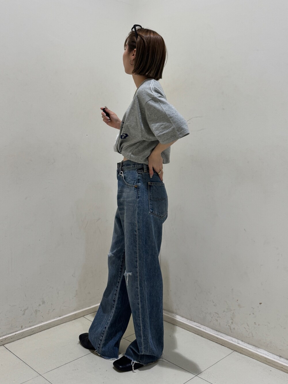 ブルー系のデニムパンツ、グレー系のTシャツ/カットソー、シルバー系のネックレスを着用したレディースの春コーディネートの2枚目の写真