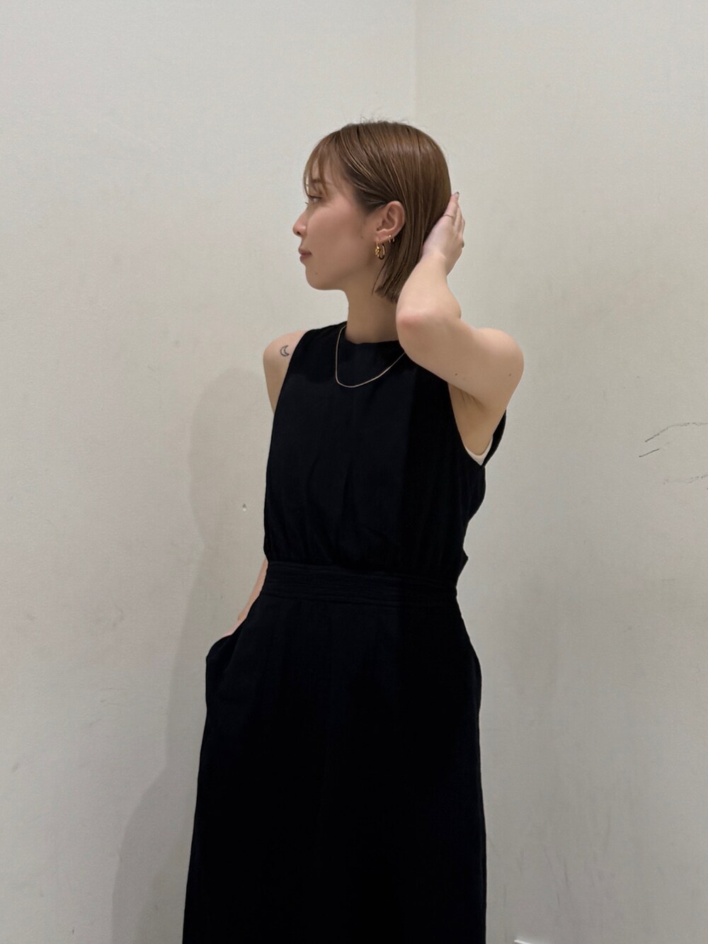 ホワイト系のキャミソール、ブラック系のワンピースを着用したレディースの夏コーディネートの4枚目の写真