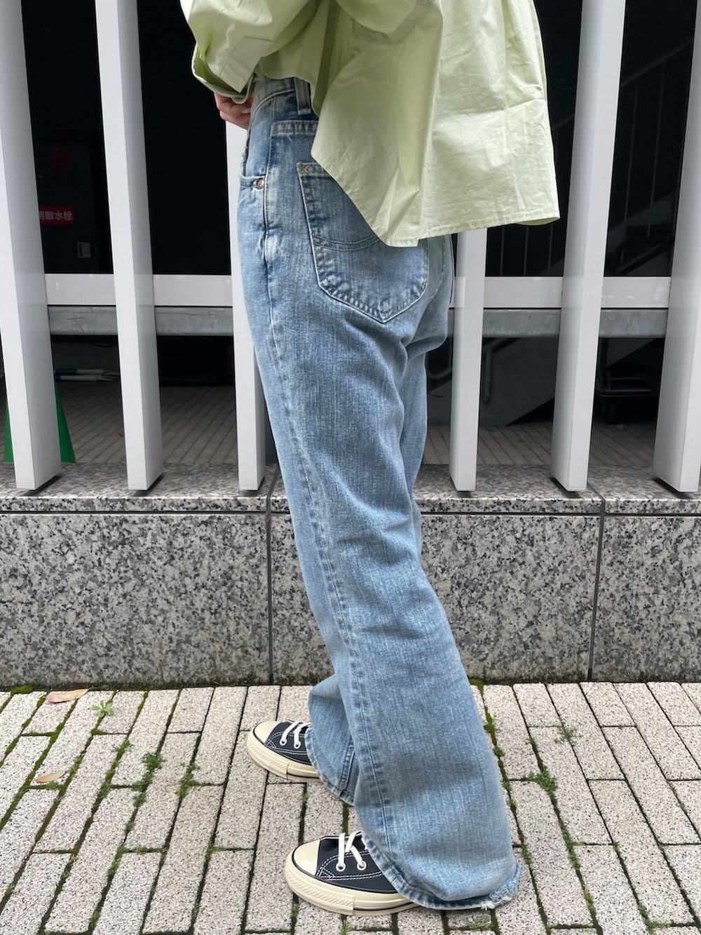 グリーン系のシャツ/ブラウス、ホワイト系のキャミソール、ブルー系のデニムパンツを着用したレディースの春コーディネートの6枚目の写真