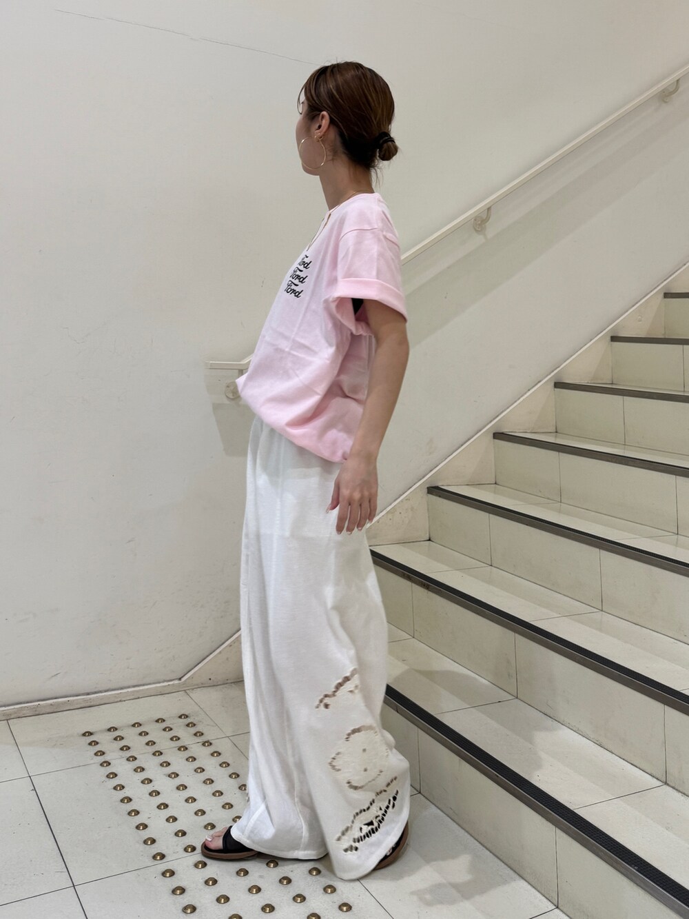 ピンク系のTシャツ/カットソー、ホワイト系のその他パンツ、ブラック系のサンダルを着用したレディースの夏コーディネートの2枚目の写真