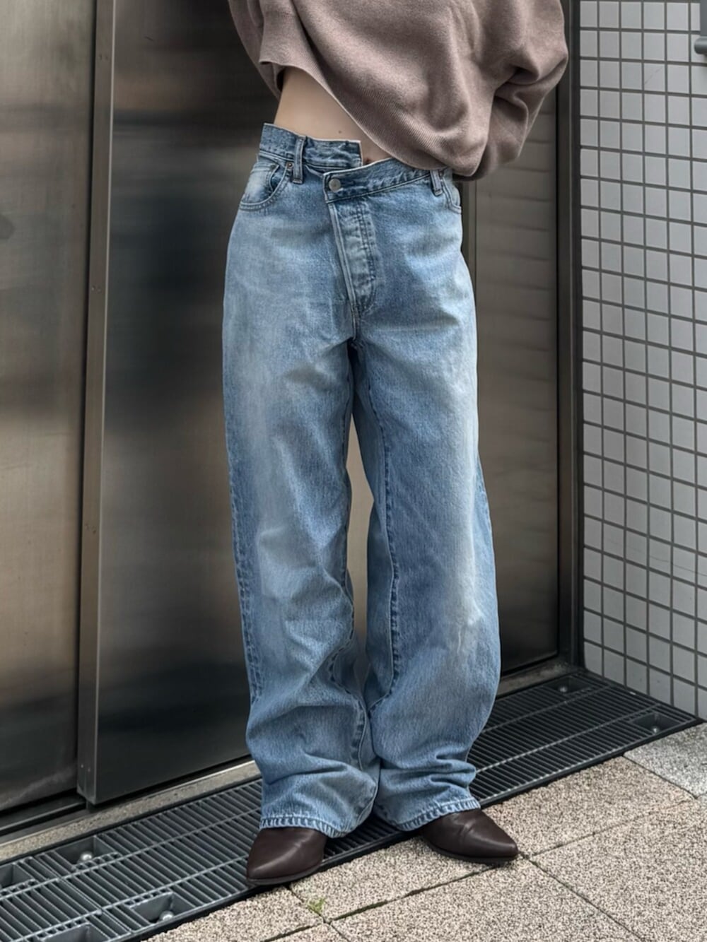 ブラウン系のブーツ、ブルー系のデニムパンツ、ベージュ系のニット/セーターを着用したレディースの秋コーディネートの4枚目の写真