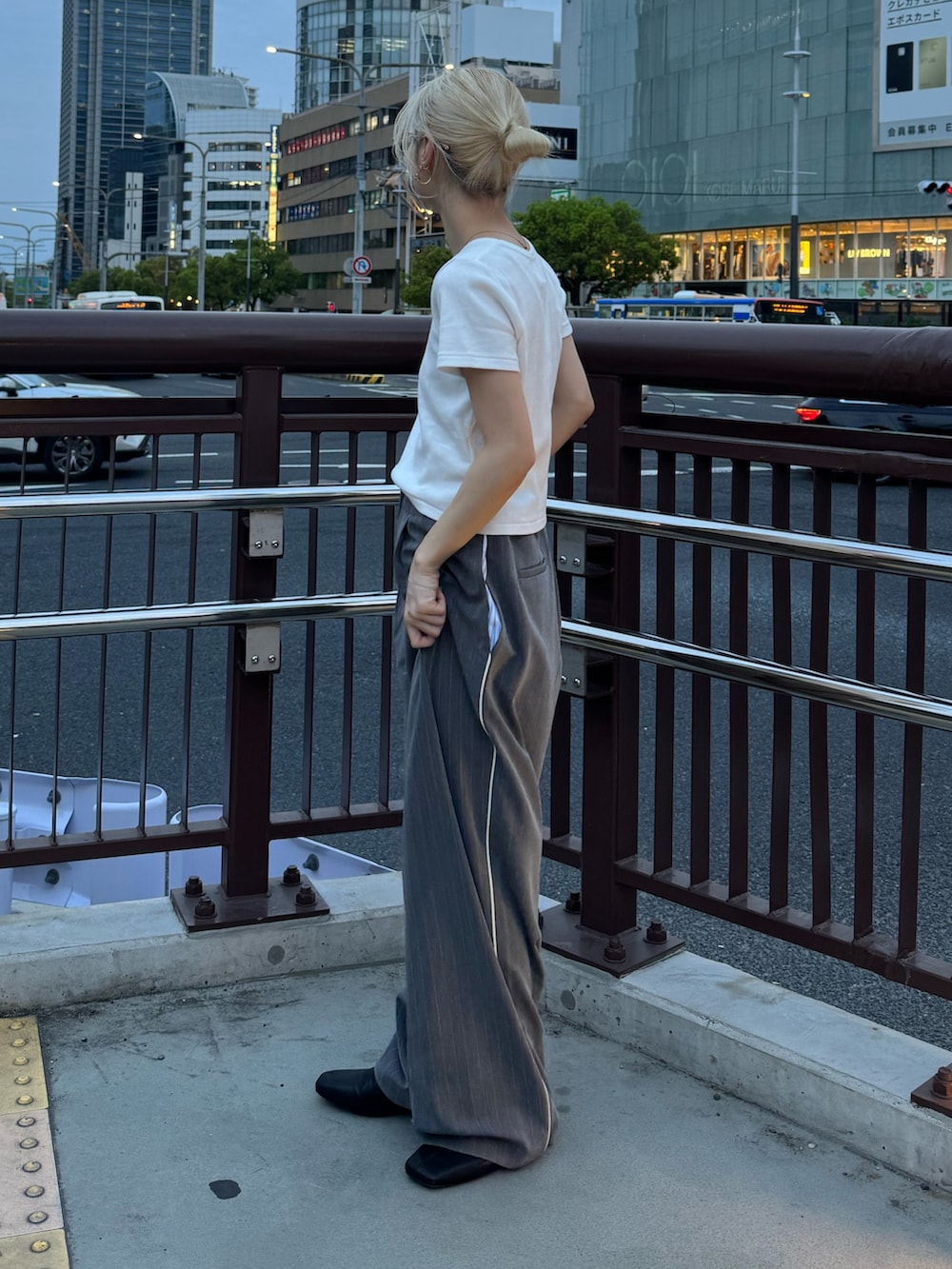 ホワイト系のTシャツ/カットソー、グレー系のその他パンツ、ブラック系のサンダルを着用したレディースの春コーディネートの2枚目の写真