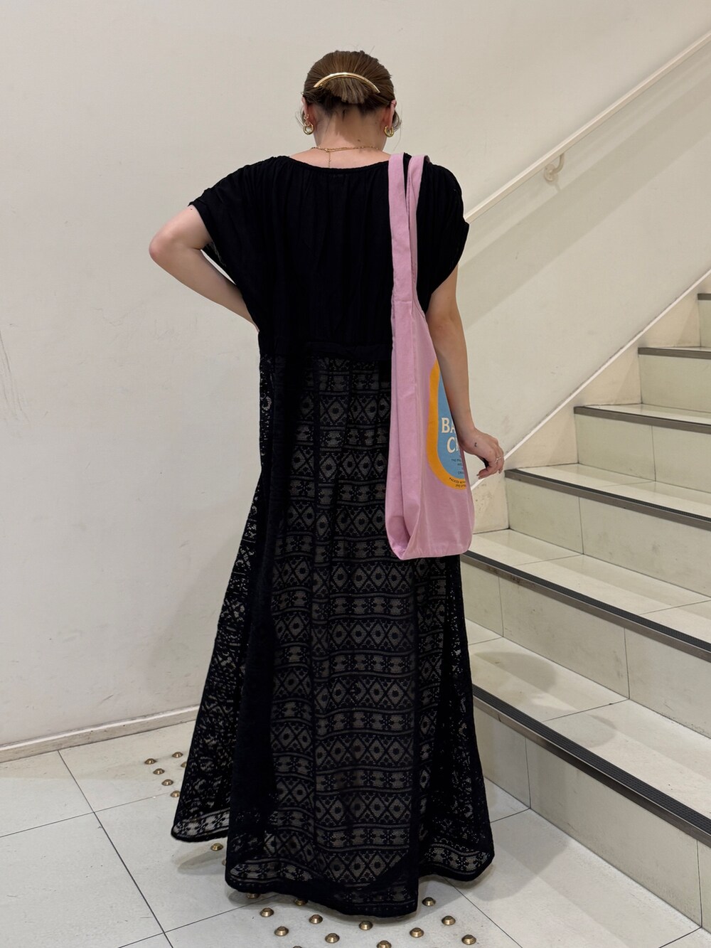 ブラック系のワンピース、ホワイト系のデニムパンツ、ピンク系のトートバッグを着用したレディースの夏コーディネートの3枚目の写真