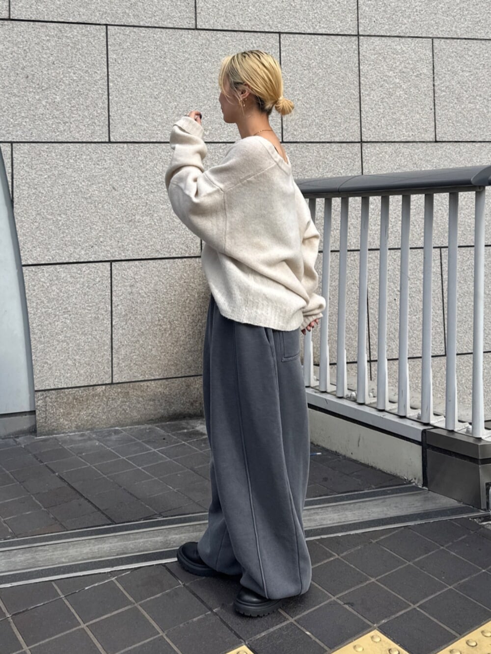 グレー系のスウェットパンツ、ホワイト系のニット/セーターを着用したレディースの秋コーディネートの2枚目の写真