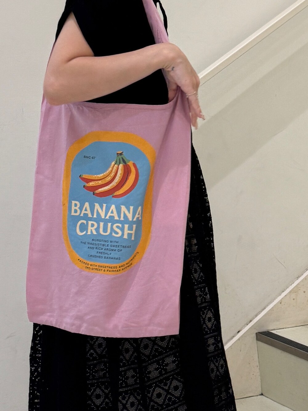 ブラック系のワンピース、ホワイト系のデニムパンツ、ピンク系のトートバッグを着用したレディースの夏コーディネートの5枚目の写真