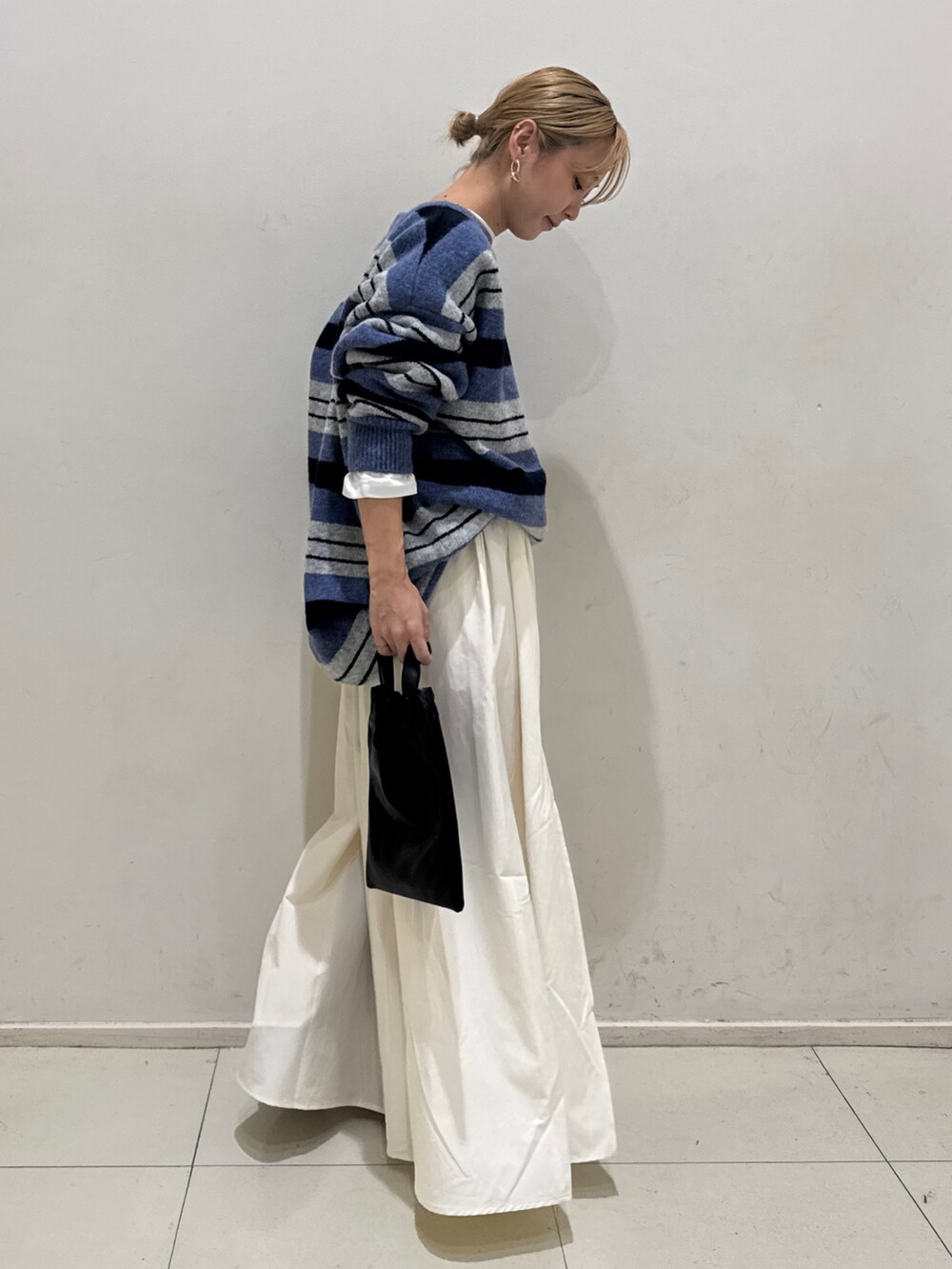 ブルー系のニット/セーター、ホワイト系のTシャツ/カットソー、ホワイト系のスカートを着用したレディースの秋コーディネートの2枚目の写真