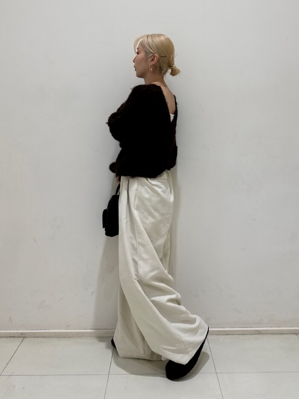 ブラック系のショルダーバッグ、ホワイト系のその他パンツ、ブラック系のスリッポンを着用したレディースの秋コーディネートの2枚目の写真