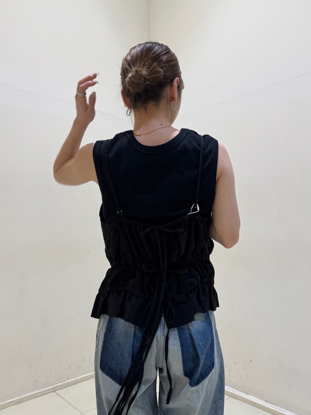 ブラック系のタンクトップ、ブルー系のデニムパンツ、ブラック系のサンダルを着用したレディースの春コーディネートの6枚目の写真